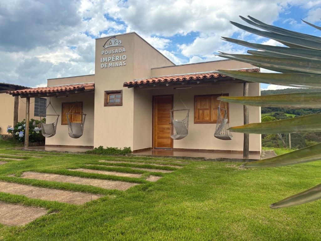 uma casa com um gramado na frente em Pousada Império de Minas em Capitólio
