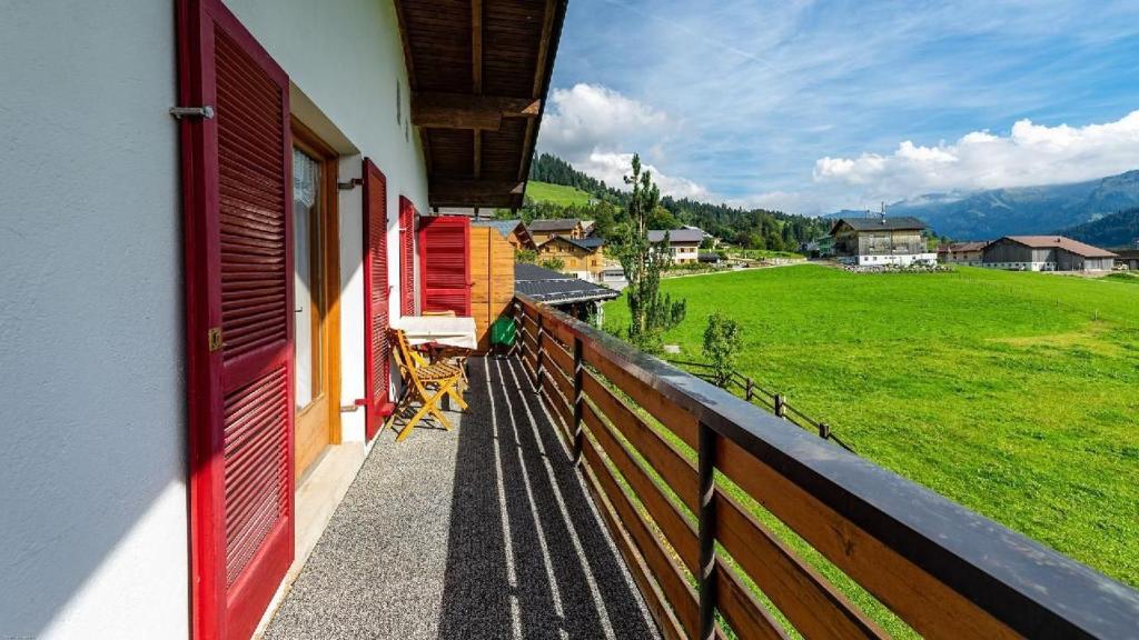 a balcony of a house with a view of a field at Ferienwohnung Haus Kipfen In Sibratsgfäll in Sibratsgfäll