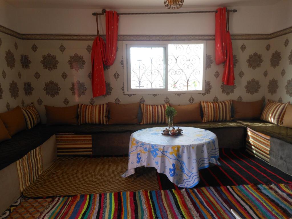una sala de estar con una mesa y un sofá en tasurft house imsoune, en Imsouane