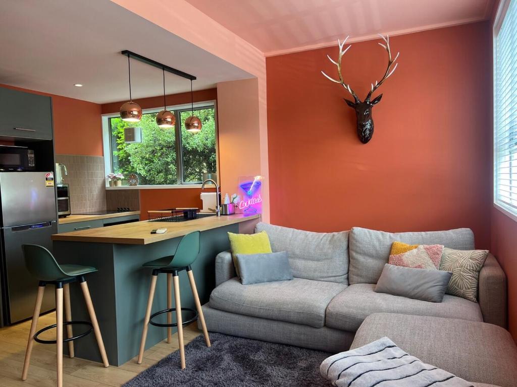 ein Wohnzimmer mit Sofa und eine Küche in der Unterkunft El Gran - Quiet, Central & Scenic Apartment in Wanaka