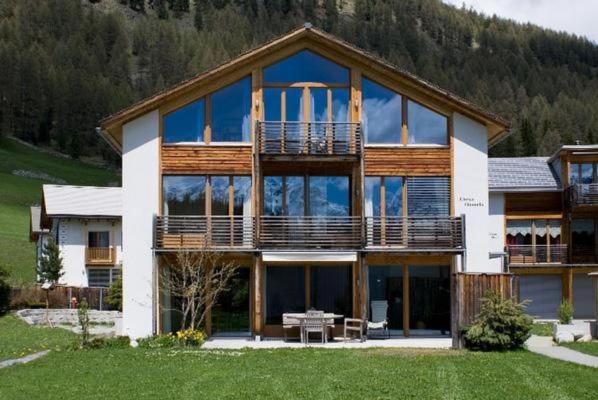 ein großes Haus mit vielen Fenstern in der Unterkunft Chesa Filomela in Bever