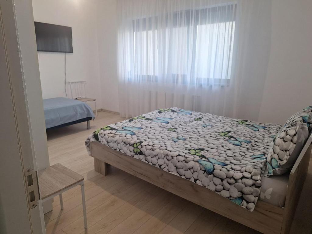 a bedroom with a bed and a television in a room at Apartament Sos Alexandriei Bragadiru in Bragadiru