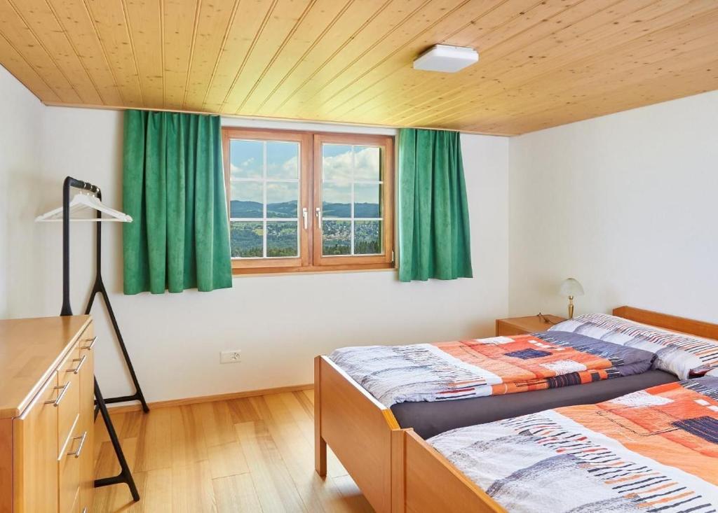 deux lits dans une chambre avec des rideaux verts dans l'établissement Hof Höchi, à Bruggen