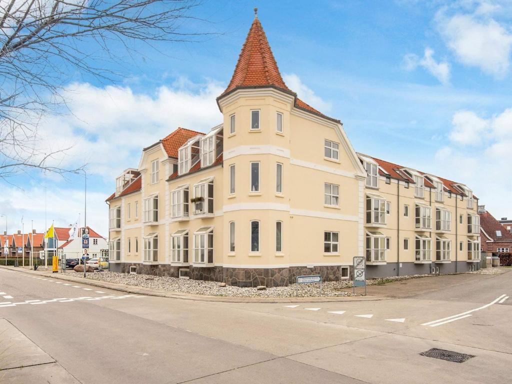 a large white building with a tower on a street at 4 star holiday home in Hejls in Hejlsminde