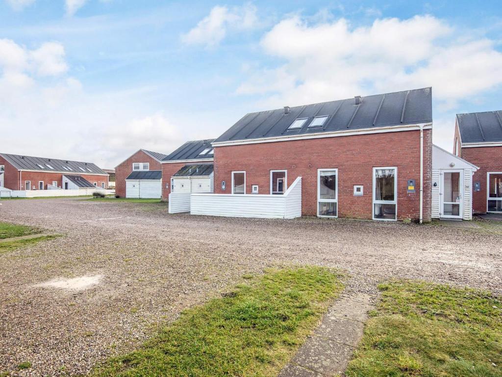 ein rotes Backsteingebäude mit schwarzem Dach in der Unterkunft 6 person holiday home in Rømø-By Traum in Sønderby