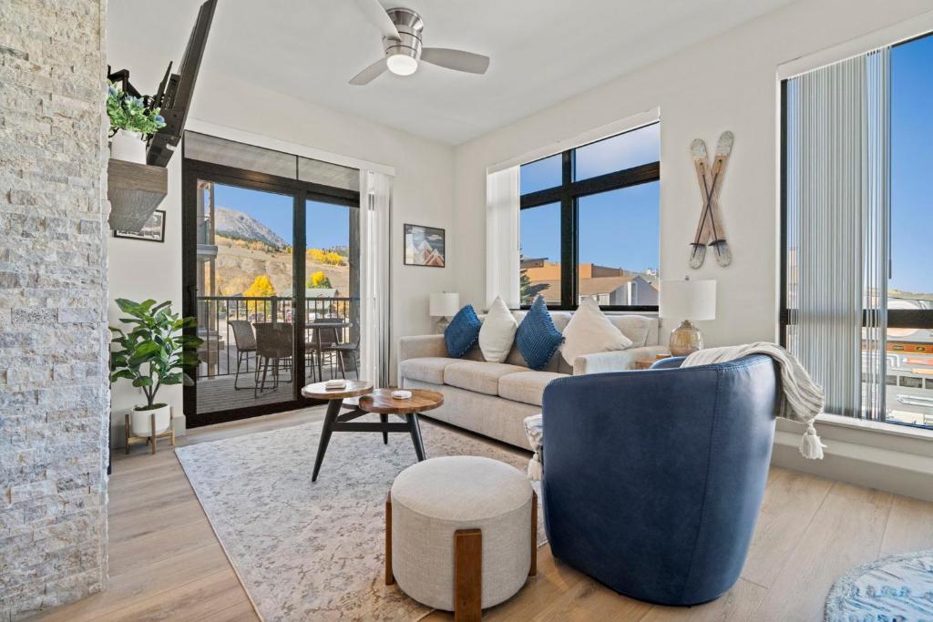 a living room with a couch and a blue chair at Skywalk Flats Mountainview Condo: Downtown, Rooftop Hot Tubs in Silverthorne