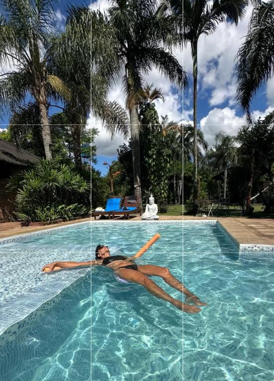 a woman laying in the water in a swimming pool at Lodge Parana Ranch in Ituzaingó