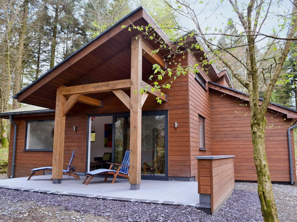 a cabin with a large glass door in the woods at Glan-Y-Gors in Beddgelert