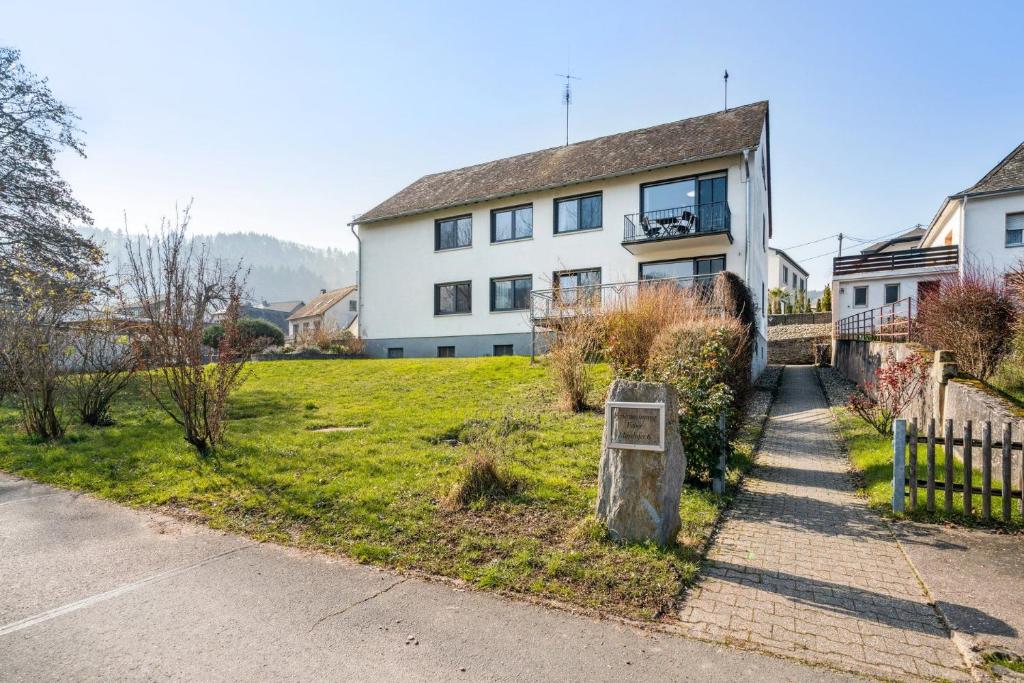 une maison blanche avec une clôture devant dans l'établissement Ferienwohnung Mit Balkon Und Schönem Moselblick, à Schleich
