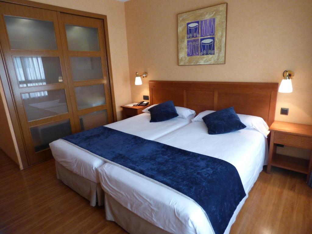 Habitación de hotel con 2 camas y almohadas azules en Eco Via Lusitana, en Madrid