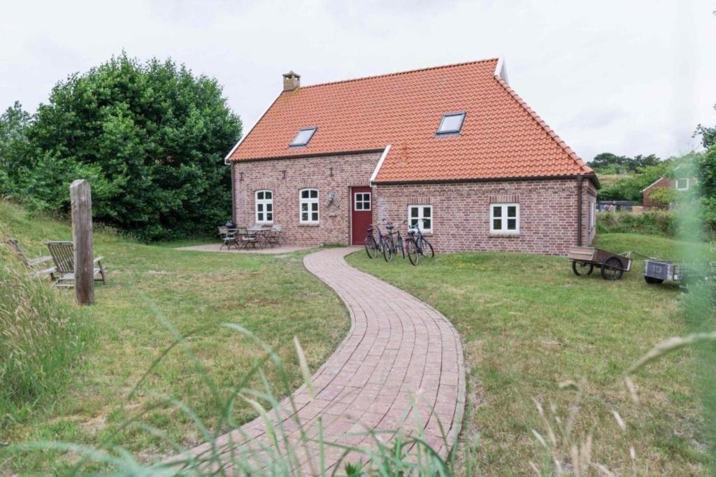 een stenen huis met een pad dat er naar toe leidt bij Inselhaus 313 in Baltrum