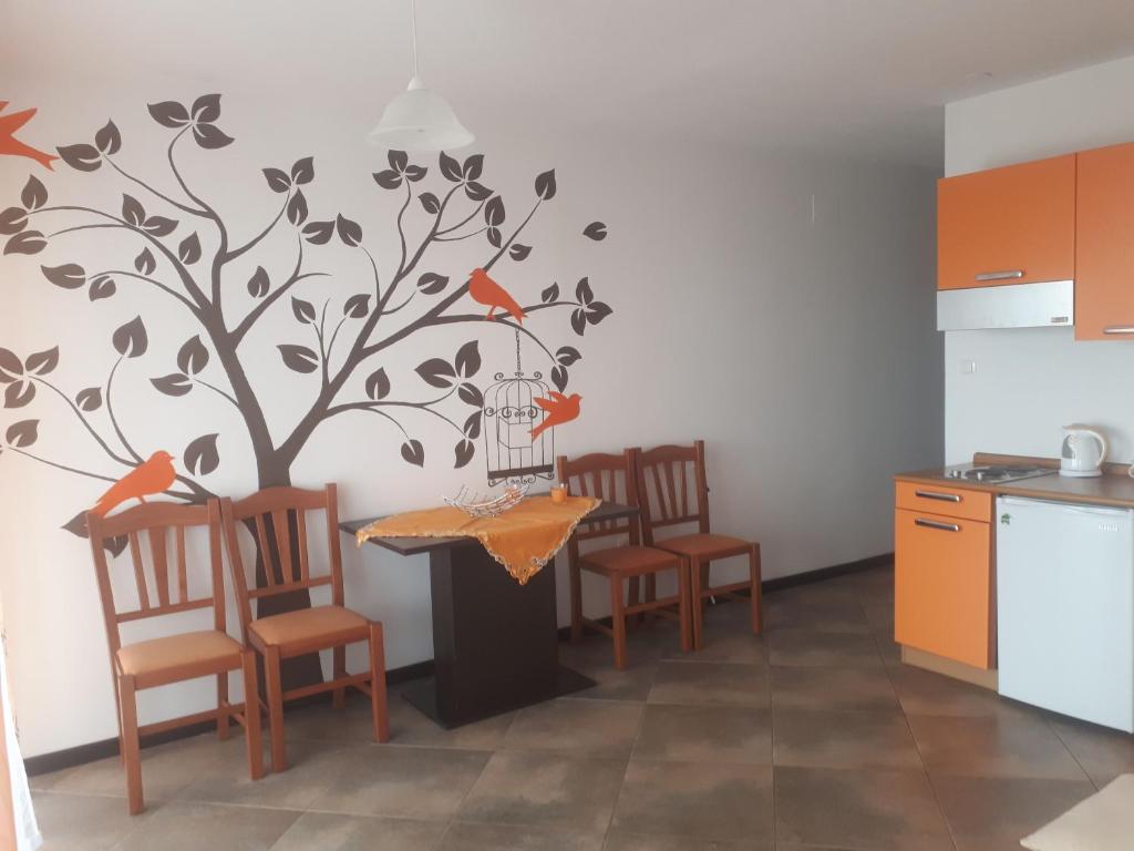a kitchen with a tree and a table with chairs at Charmante Wohnung Adriana F in Dobreć