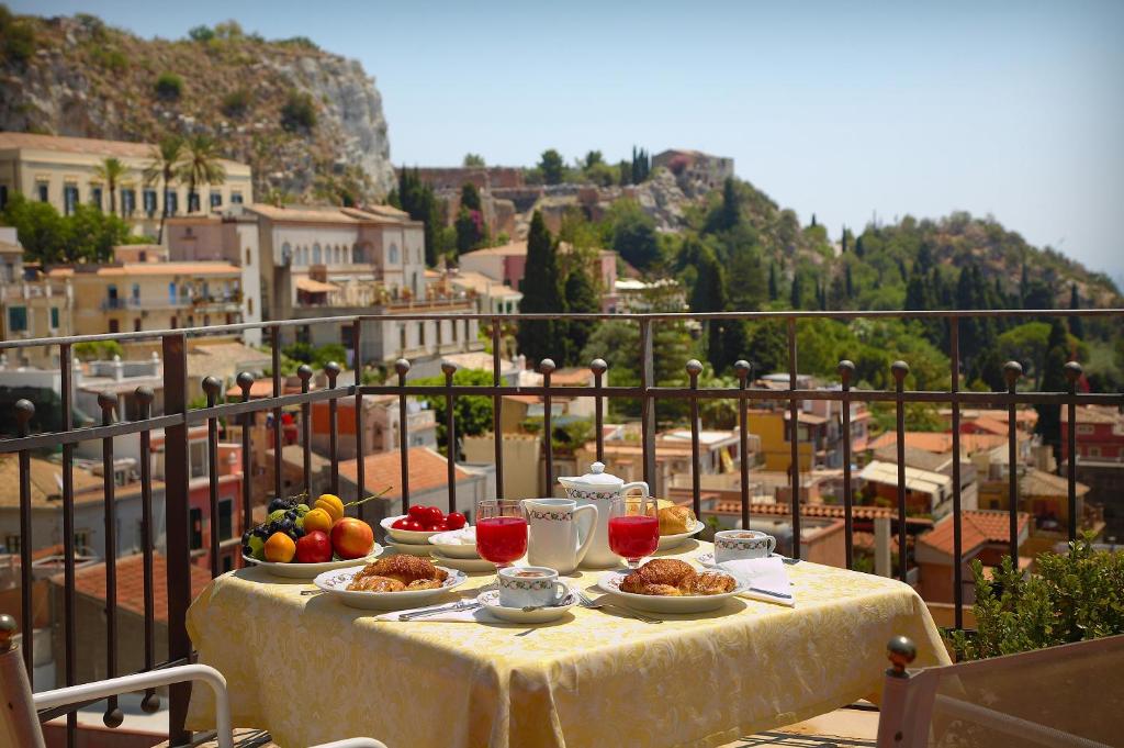 un tavolo con piatti di cibo in cima a un balcone di Hotel Isabella a Taormina