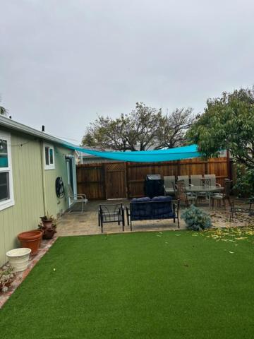 圣巴巴拉Goodland Green House的一个带露台的院子，露台上盖着蓝色遮阳篷。