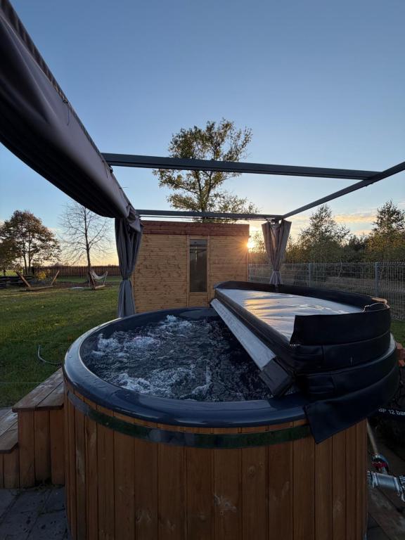 a hot tub in a backyard with an umbrella at Agroturystyka AKPólko in Biała Podlaska