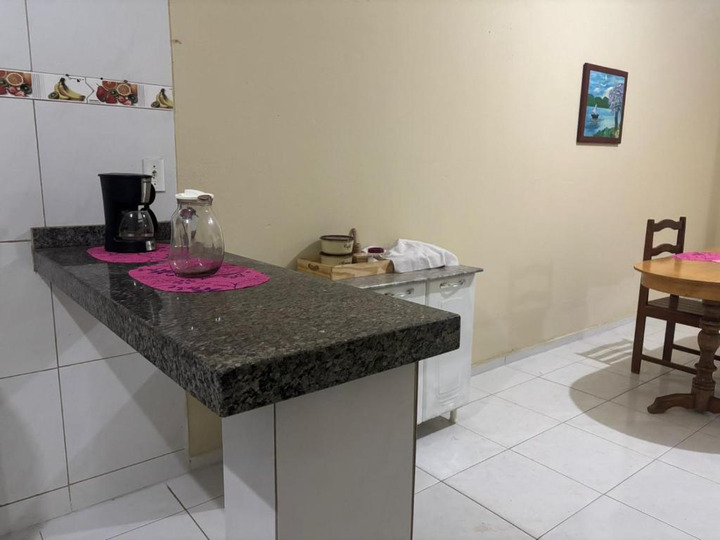 a kitchen with a granite counter top and a table at Casa de temporada in Tianguá
