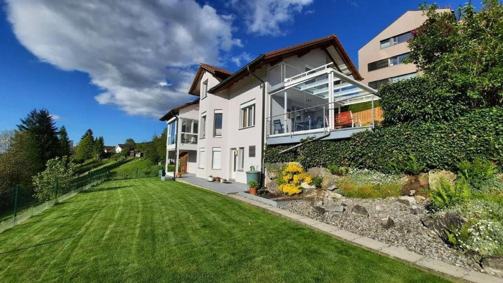 Una gran casa blanca con un patio de césped. en Angenweg 2, en Entlebuch