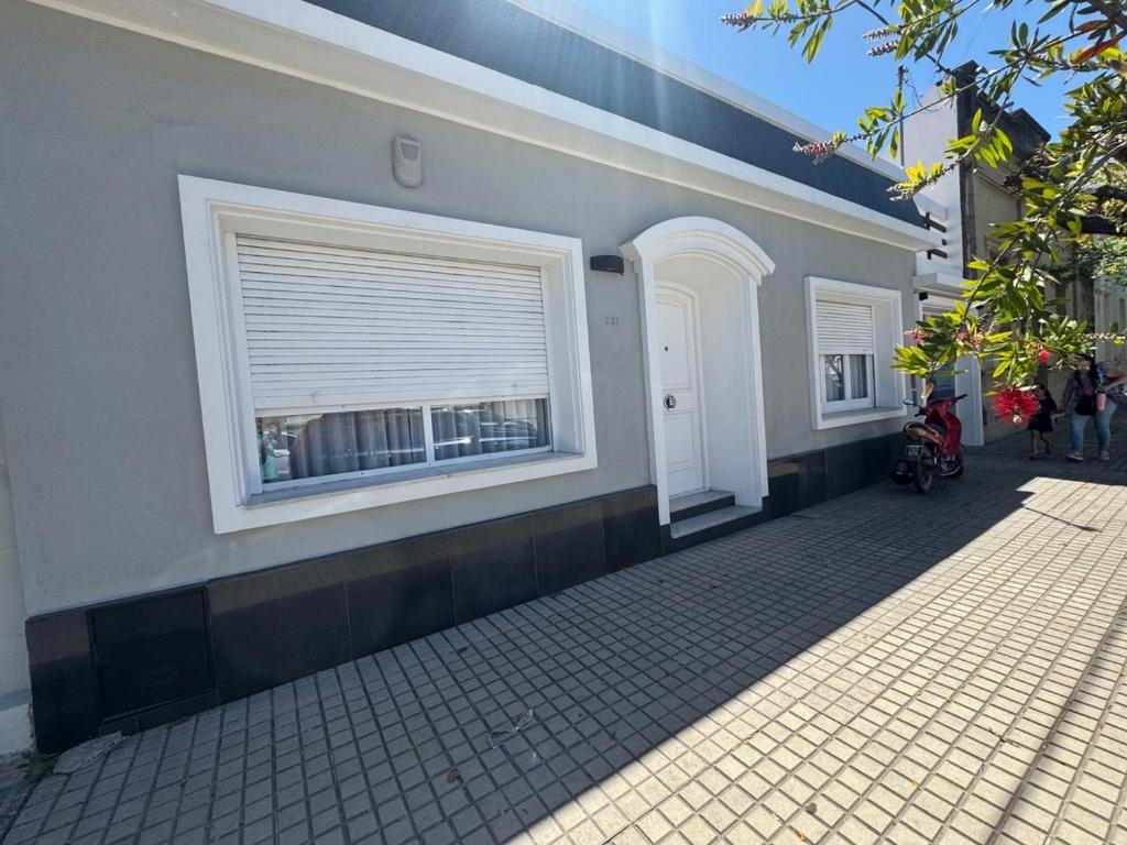 un edificio con una ventana y una acera en La Casona, en Alta Gracia
