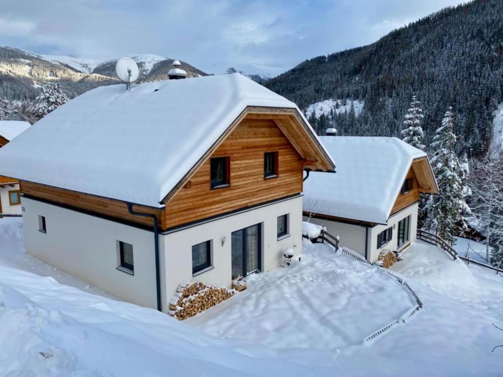 une maison avec de la neige sur le toit dans l'établissement Sauna Chalet Ahorn, à Staudach