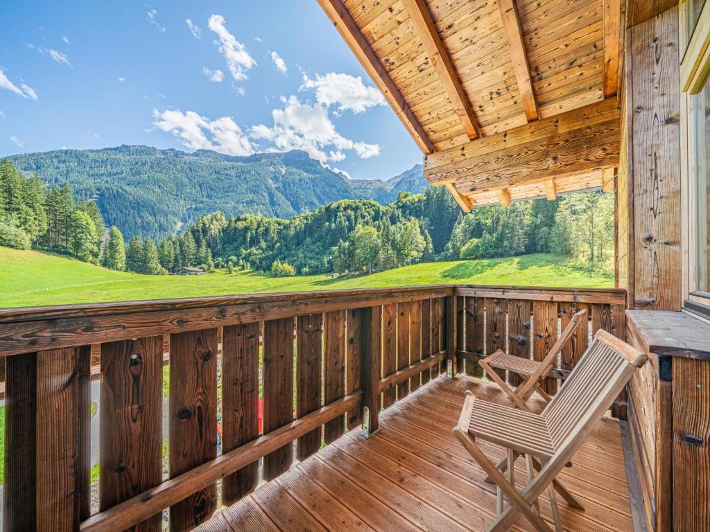 a rocking chair on a porch with a view of mountains at Haus Bergstille Top 3 in Vorderkrimml