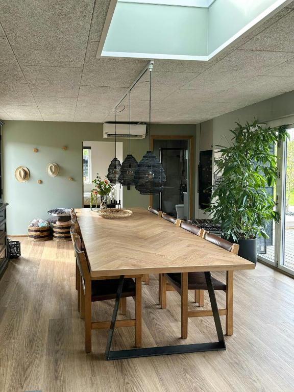 jadalnia z dużym drewnianym stołem i krzesłami w obiekcie Summer House Near The Beach At Grønninghoved w mieście Binderup Strand