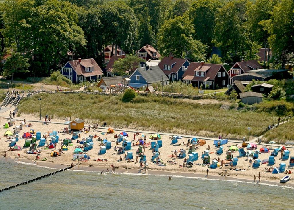 eine Gruppe von Menschen am Strand mit Sonnenschirmen in der Unterkunft SEETELHOTEL Nautic Usedom Dünenhäuser in Ückeritz