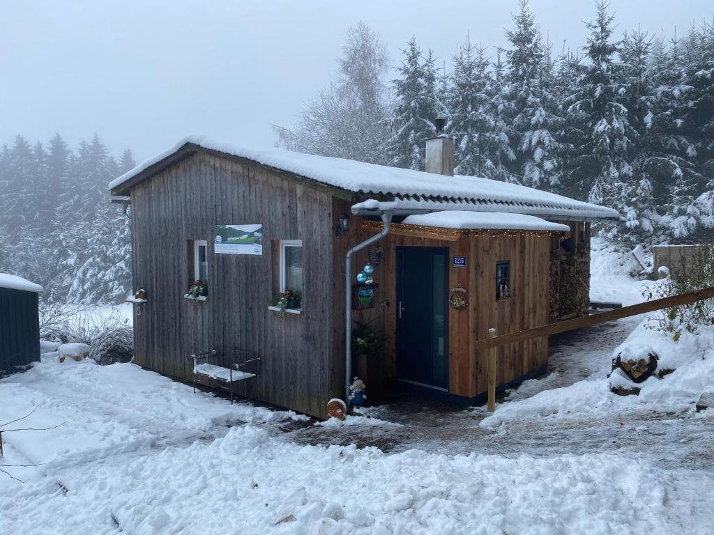 une cabane en bois avec de la neige sur le toit dans l'établissement Herzhütte Für Zwei, à Vichtenstein