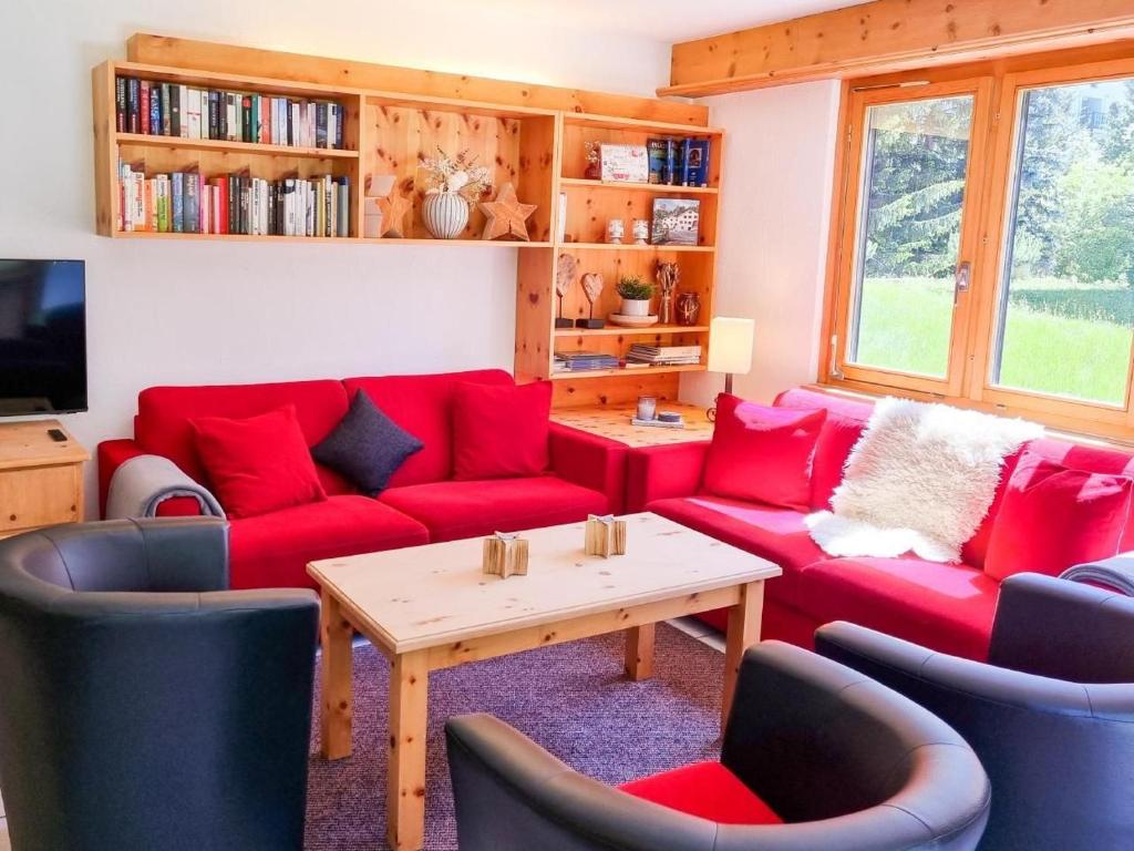 uma sala de estar com sofás vermelhos e uma mesa em Curtins16 em Pontresina