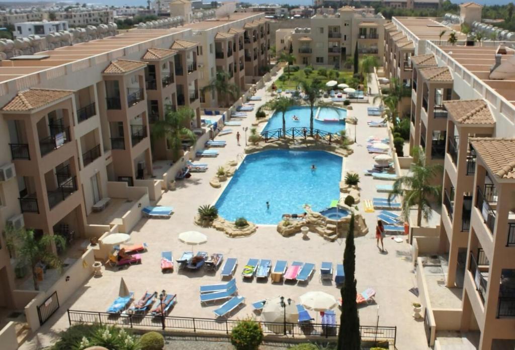 帕福斯Front pool garden apartment的享有度假村游泳池的空中景致