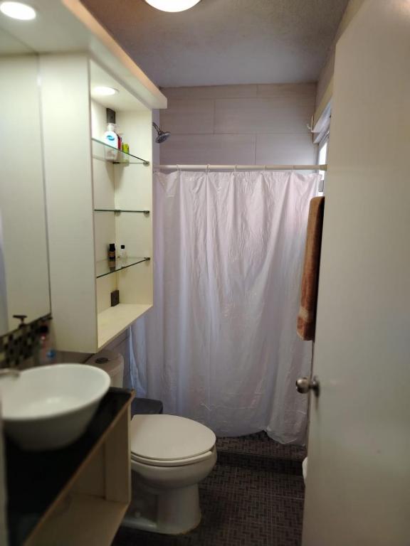 a bathroom with a white toilet and a sink at Bonaterra in El Jobo