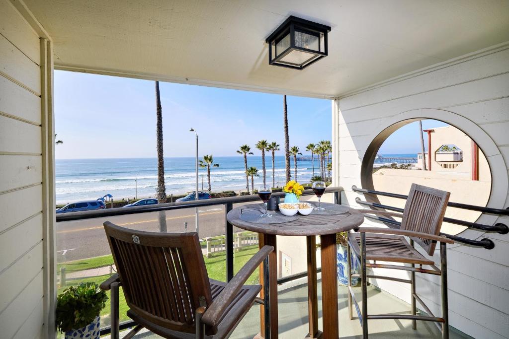 a table and chairs on a balcony with a view of the beach at 152-4 Coastal Luxury with Panoramic Ocean View in Oceanside