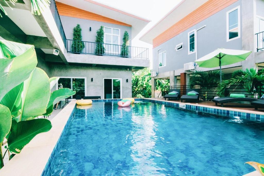 une piscine devant un bâtiment dans l'établissement Villa Rajapruek Private Villa 3 houses combine near Airport, à Chiang Mai
