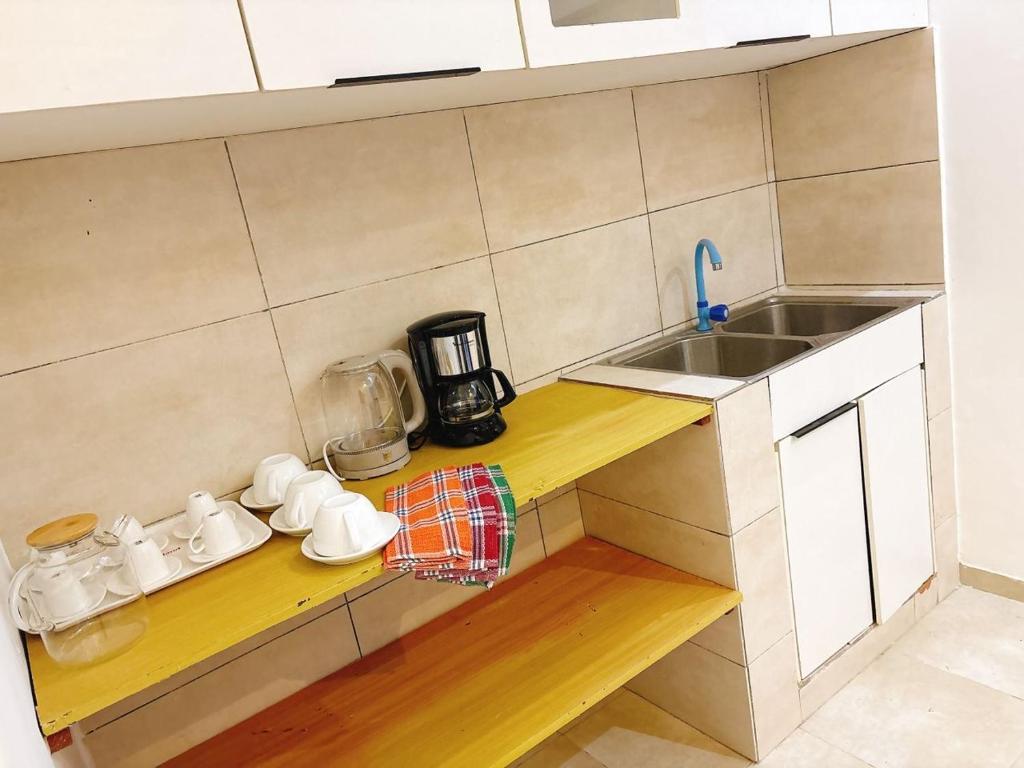 a small kitchen with a sink and a counter top at Paradis Douillet in Cotonou