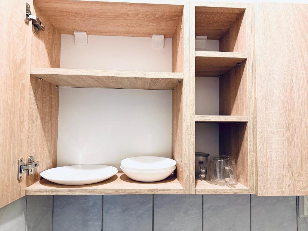 a cupboard with two white bowls in it at Circumvalațiunii Center Apartment in Timişoara