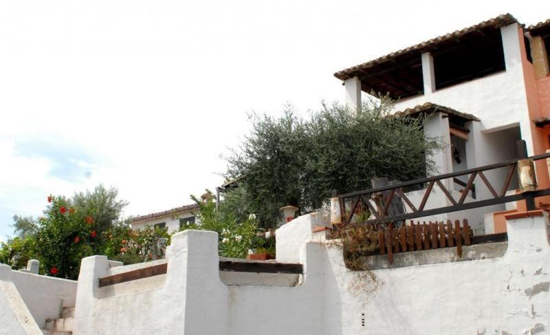 ein weißes Gebäude mit einem Zaun und einigen Büschen in der Unterkunft Ferienwohnung für 4 Personen ca 56 m in Perd'e Sali, Sardinien Golf von Cagliari in Porto Columbu - Perdʼe Sali