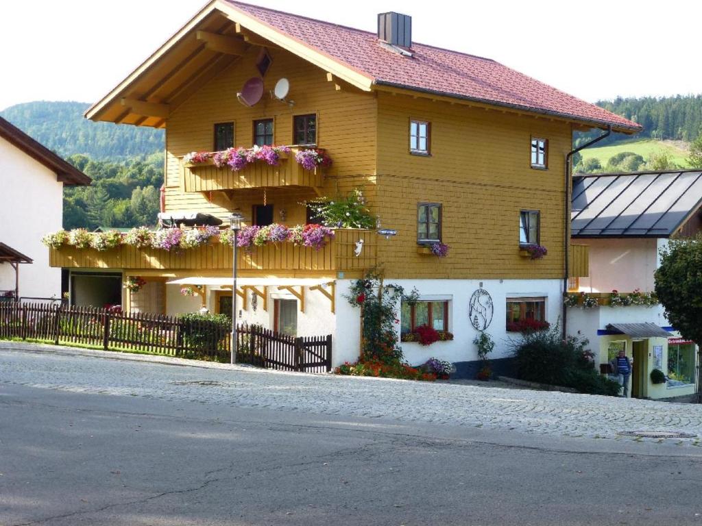 ein großes Holzhaus mit Blumenkästen drauf in der Unterkunft Ferienwohnung Koch in Bayerisch Eisenstein