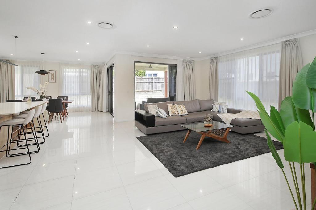 a living room with a couch and a table at The Grand Six at Rochedale in Rochedale