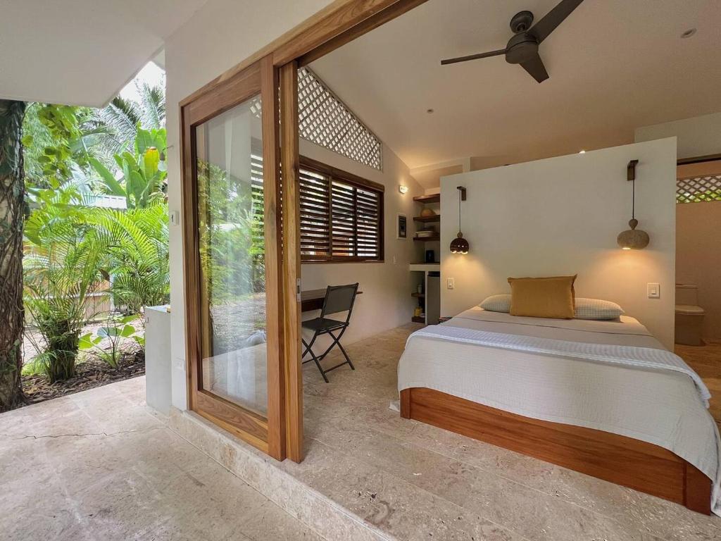une chambre avec un lit et un bureau dans l'établissement Villas Guaitil Cozy Jungle Hideaway in Playa Chiquita, à Puerto Viejo