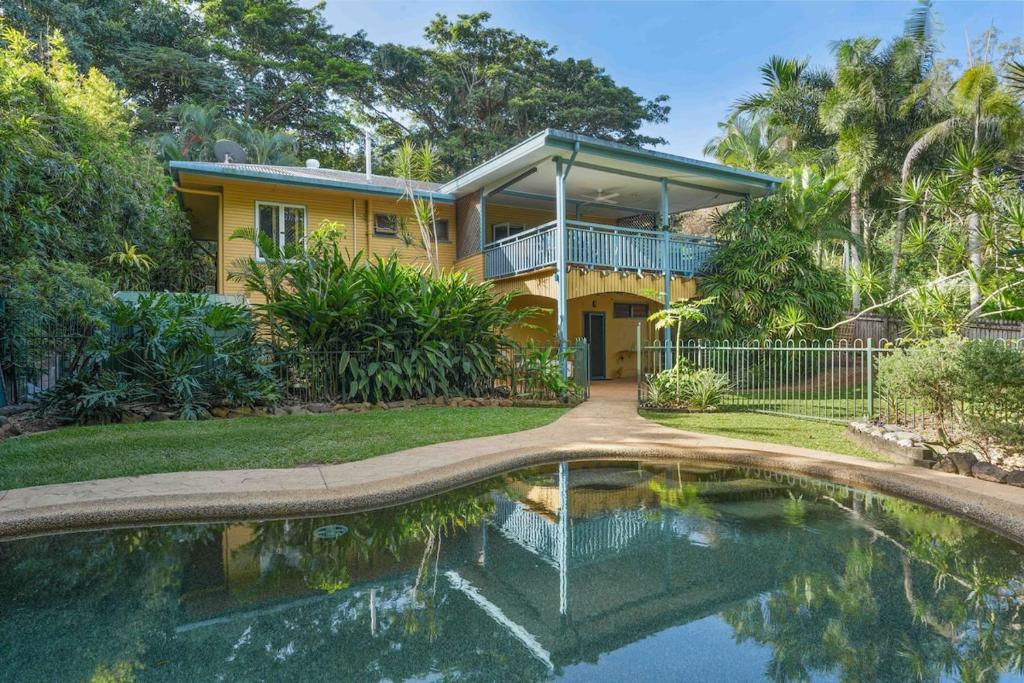 a yellow house with a pool in front of it at Edge Hill Apartment under Queenslander w Pool in Edge Hill