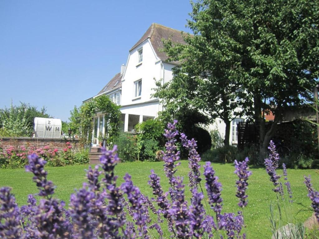a house with purple flowers in front of a yard at Wohnung In Gießelrade Mit Großem Garten in Ahrensbök