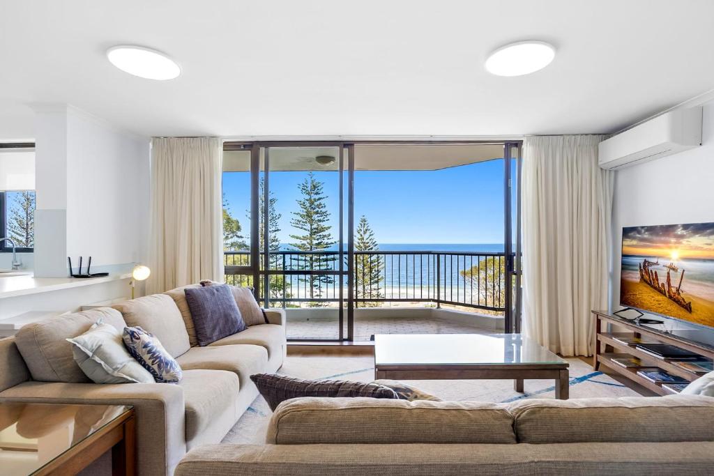 a living room with a couch and a view of the ocean at Stay in Seaview Resort, 2 BD apartment with ocean views in Mooloolaba
