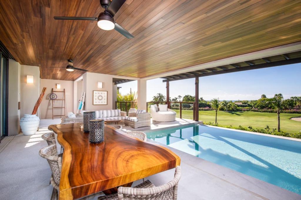 - un salon avec une table en bois et une piscine dans l'établissement 3bed Condo- Private Pool Golf Cart Ocean View HK, à Tapachula