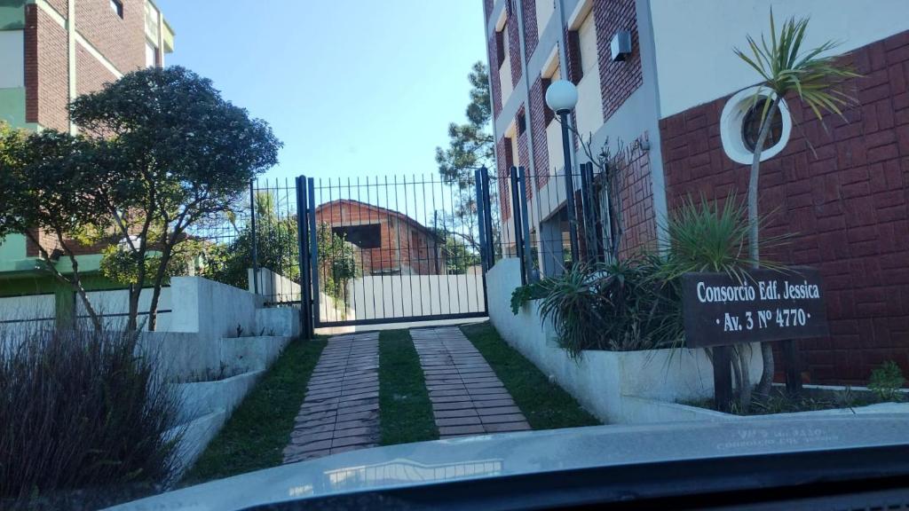 une passerelle devant un bâtiment avec une clôture dans l'établissement Departamento amoblado Villa Gesell 3 cuadras de la playa, à Villa Gesell