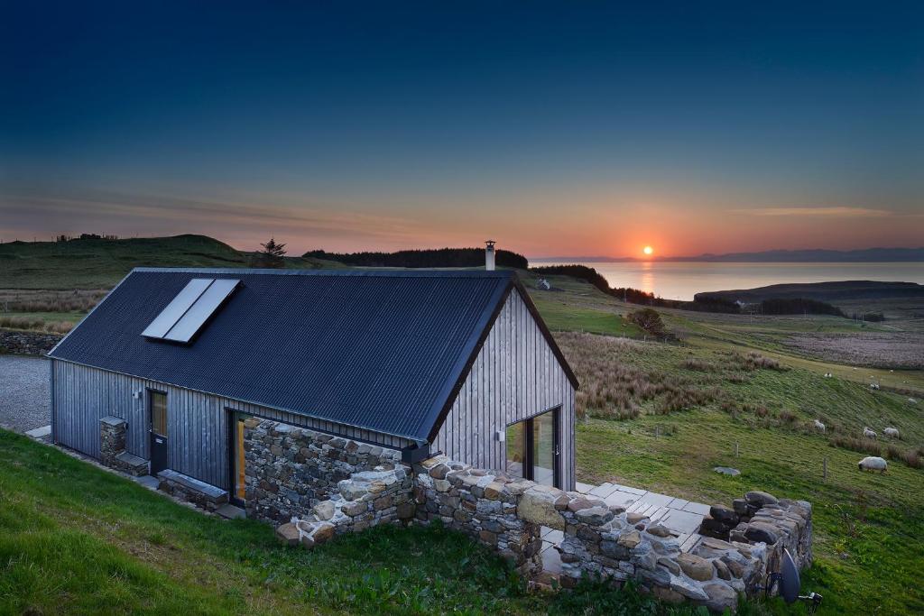 a barn with a solar roof on top of a field at Skye Eyrie in Staffin