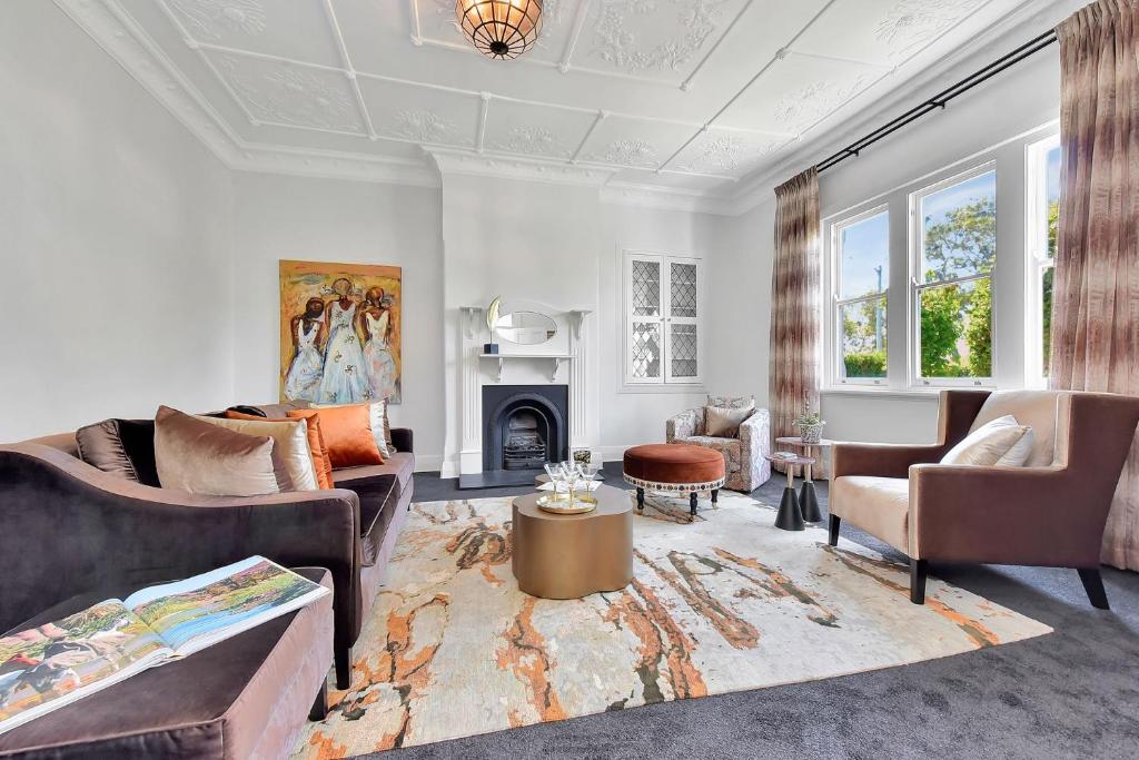 ein Wohnzimmer mit zwei Sofas und einem Kamin in der Unterkunft Merewether House 1910 - Iconic and Luxury Home in Merewether