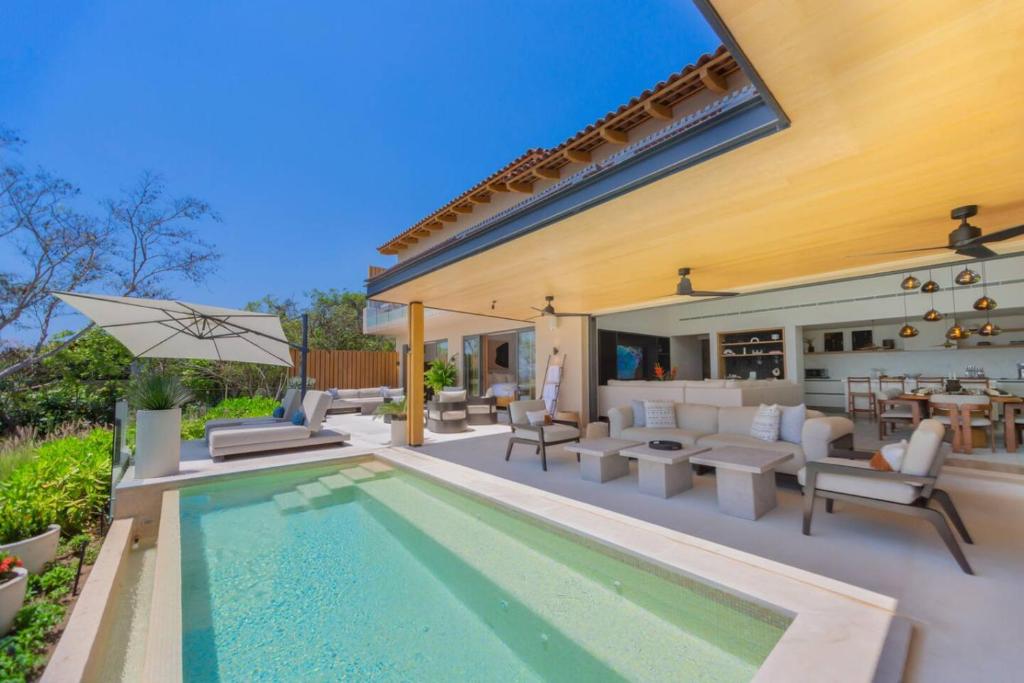 a backyard with a swimming pool and a house at 4 Bed - Luxury Oceanview Villa in Punta Mita