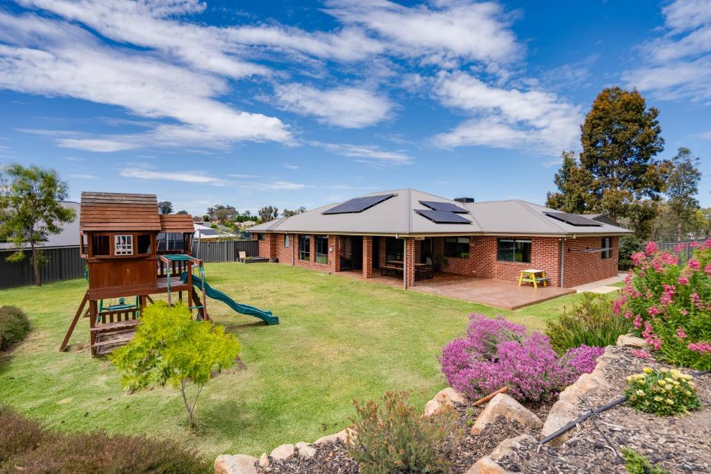 a house with a pitched roof with a playground at Alpine Corner - Lux and Quiet in Thurgoona