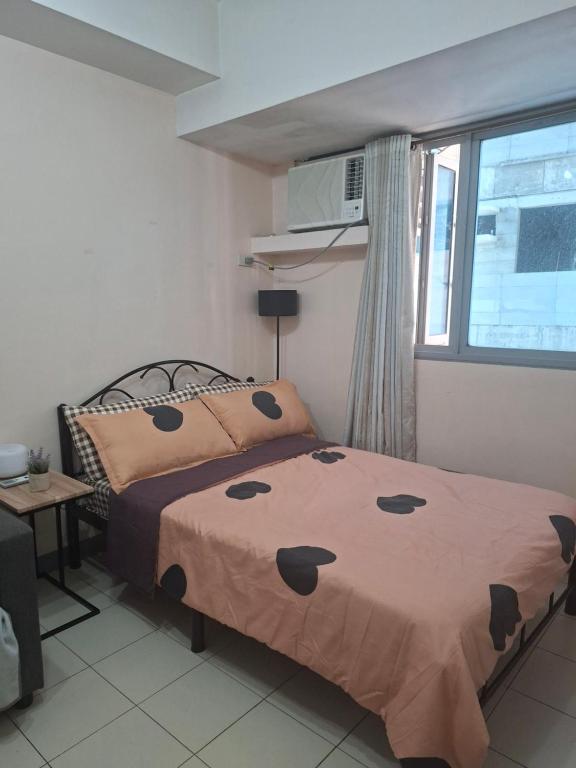 a bedroom with a bed and a window at The Grand Towers Manila in Manila