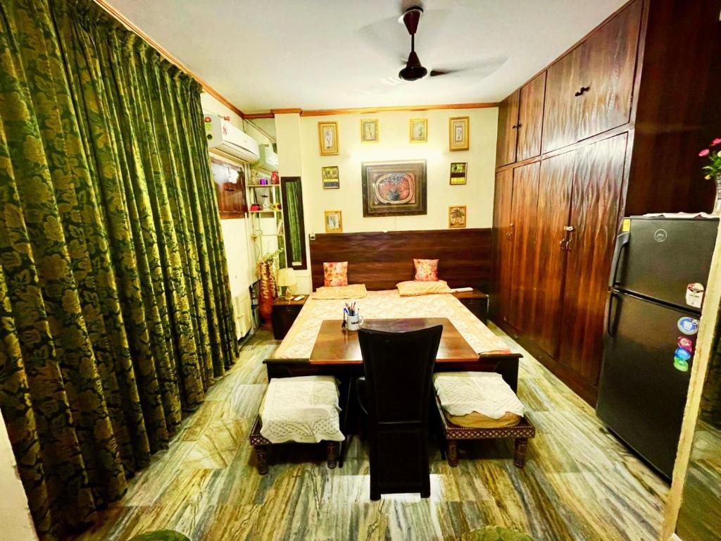 Un comedor con una mesa y un refrigerador. en Designer luxury flat with greenry best location in south Delhi, en Jāmb