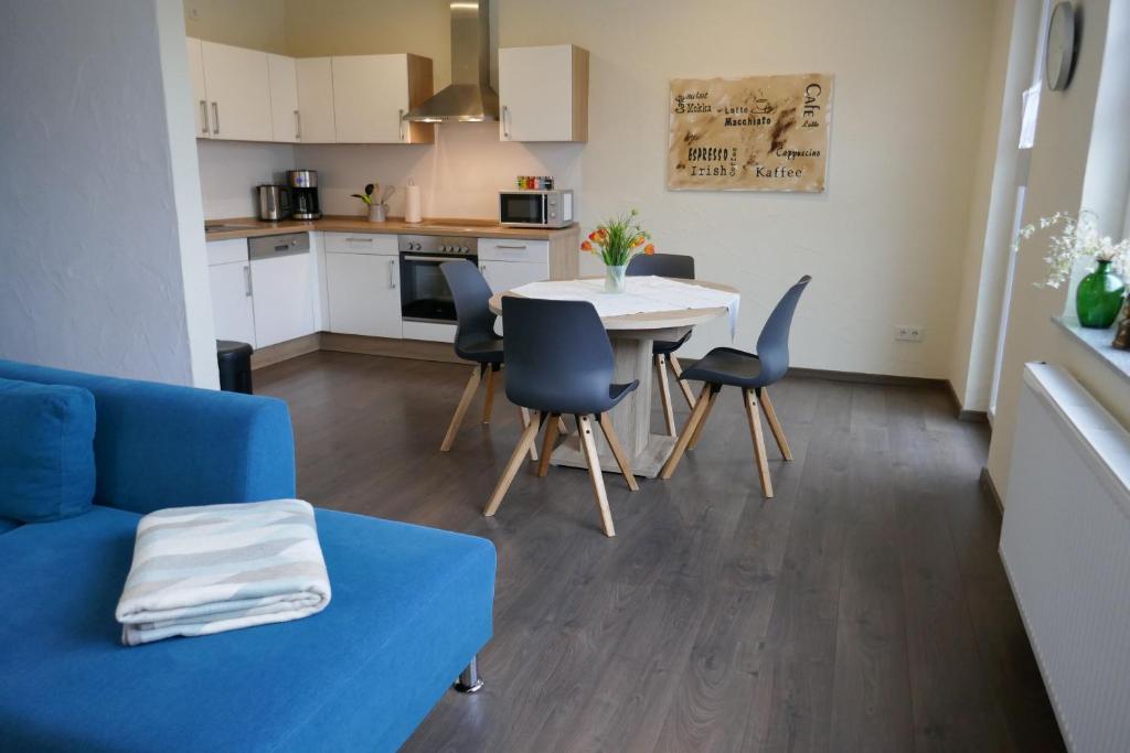 ein Wohnzimmer mit einem blauen Sofa und einem Tisch und Stühlen in der Unterkunft moderne Ferienwohnung " Ober Langengarten" mit separatem Wellnessbereich, direkt am Radweg in Pittenbach